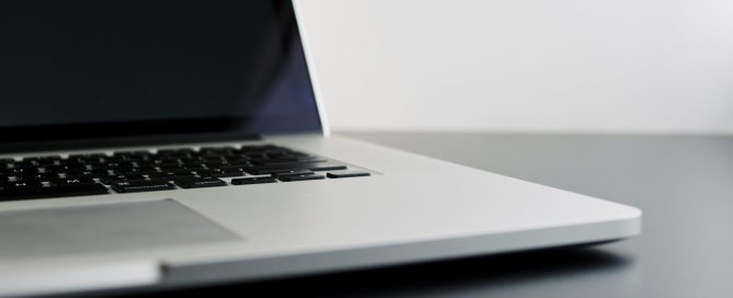 silver laptop computer on black table