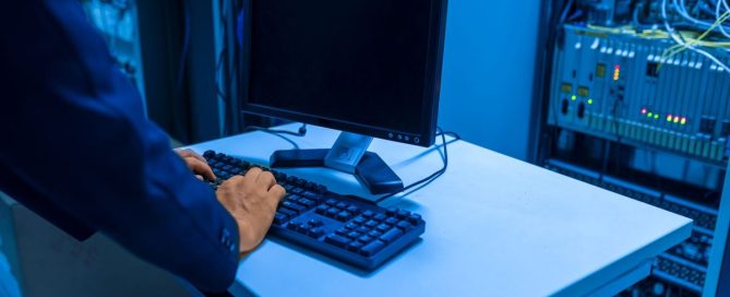 IT technician monitoring systems on dual screens