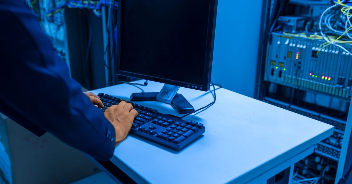 IT technician monitoring systems on dual screens
