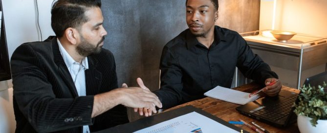 IT technician shaking hands with a small-business owner in their shop